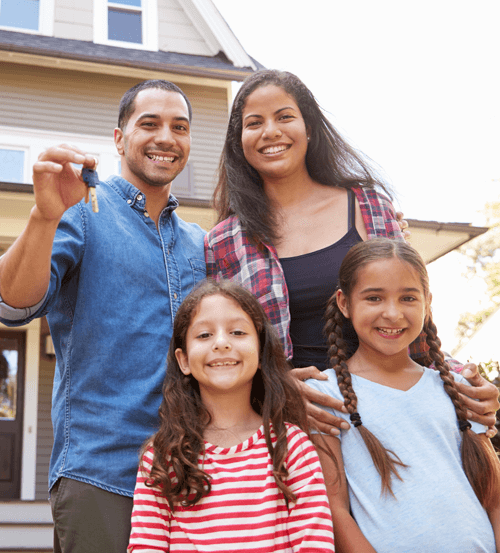 a happy family holding the keys to their new home